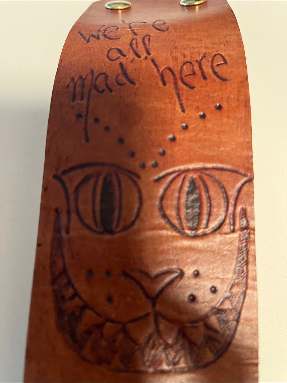 Handcrafted Brown Leather Wrist Art with Engraved Cheshire Cat Design